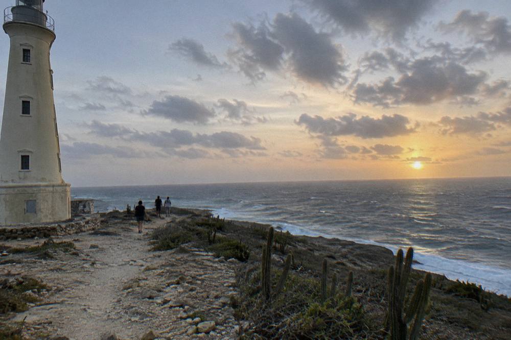 Sun hanging low over the Caribbean Sea just above a flat horizon near Aruba