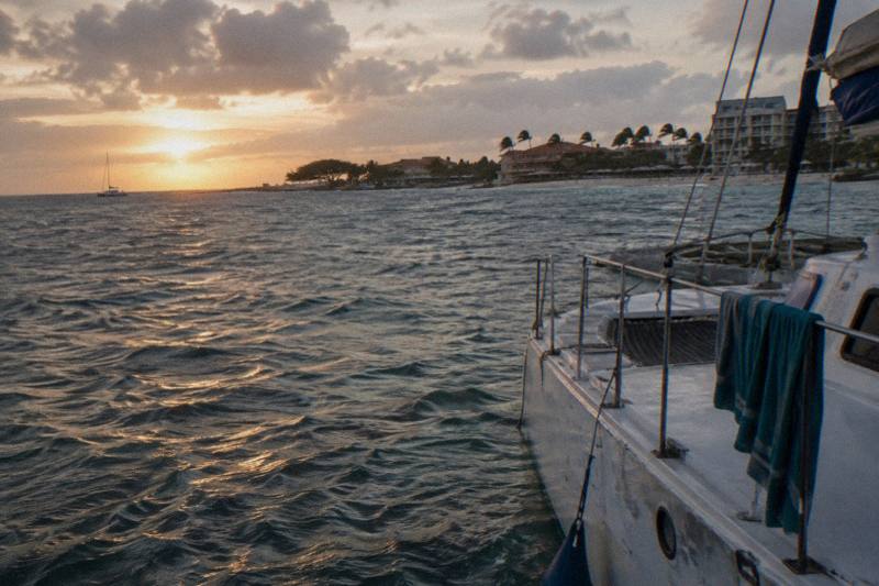 Small private catamaran anchored off Palm Beach Aruba at sunset