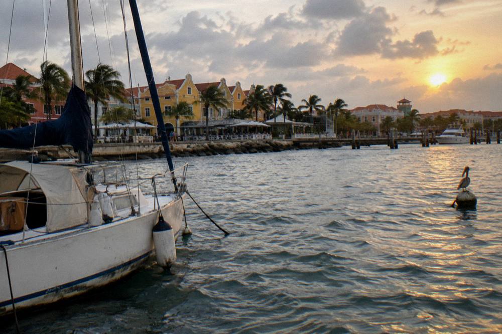 Small private sailing boat anchored in calm water near the Aruba coast at sunset