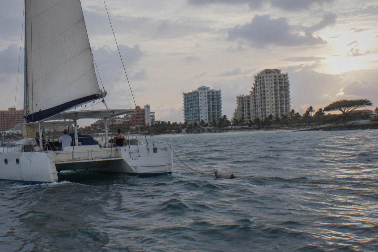 Catamaran under sail off the Palm Beach coast of Aruba at dusk