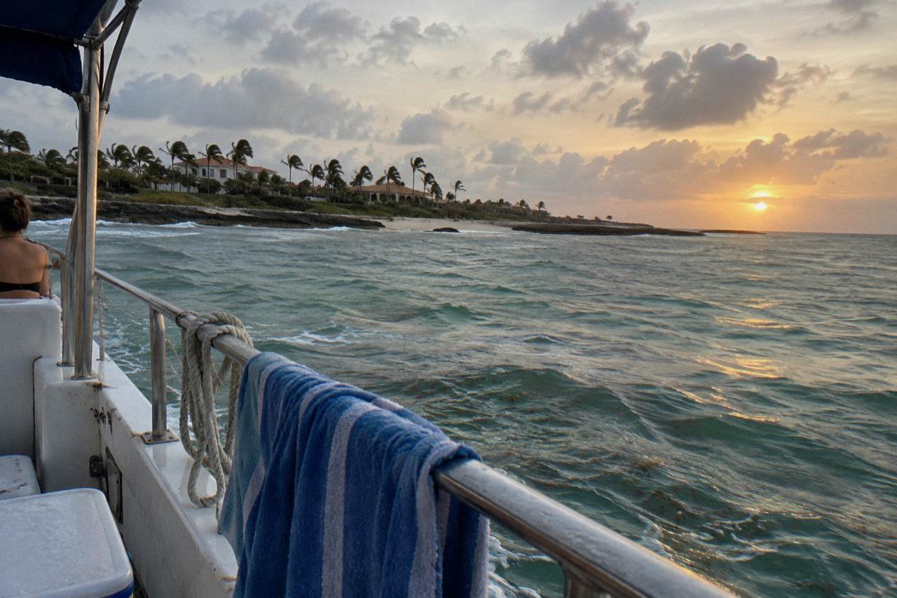 Open Caribbean horizon from a boat as the sun sinks toward the water