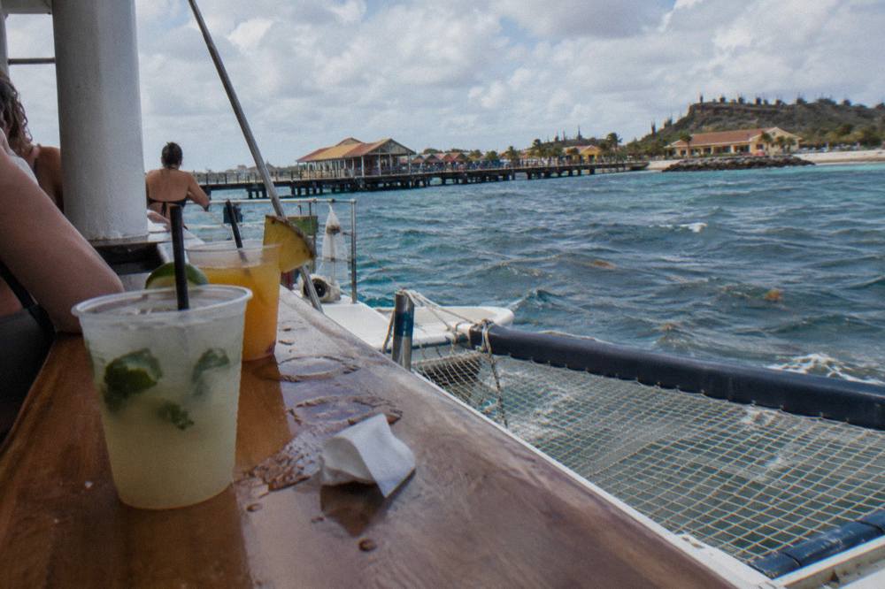 Open air catamaran deck with drinks on the bar counter above the Caribbean sea