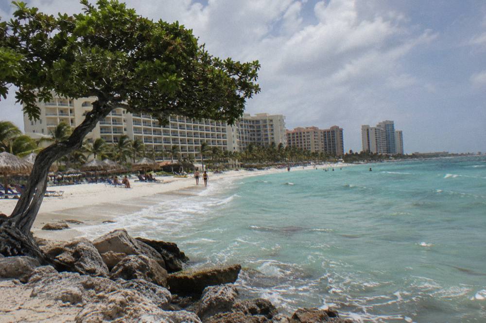 Row of beachfront resort towers along a pale sand beach with calm water