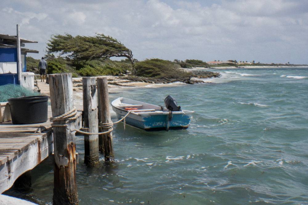 Small fishing pier over gentle waves at the quiet end of a beach