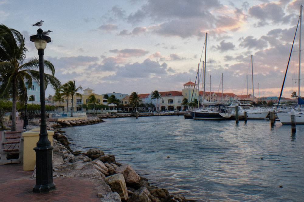 An evening sky over the Oranjestad waterfront with scattered clouds and moored boats