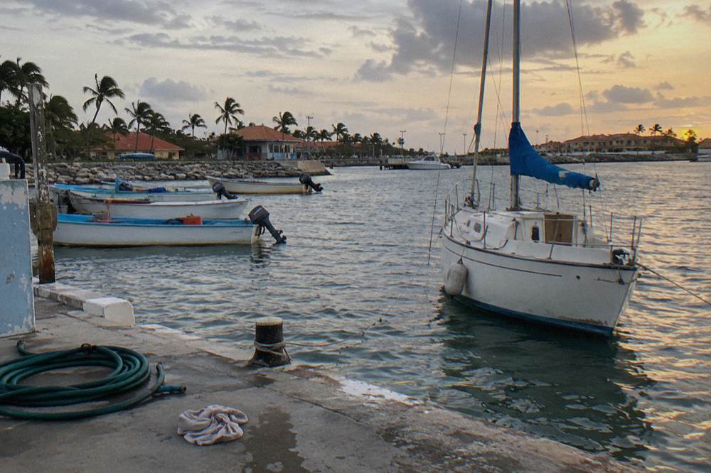 Evening sailboat anchored near Oranjestad marina under a clear sky at dusk