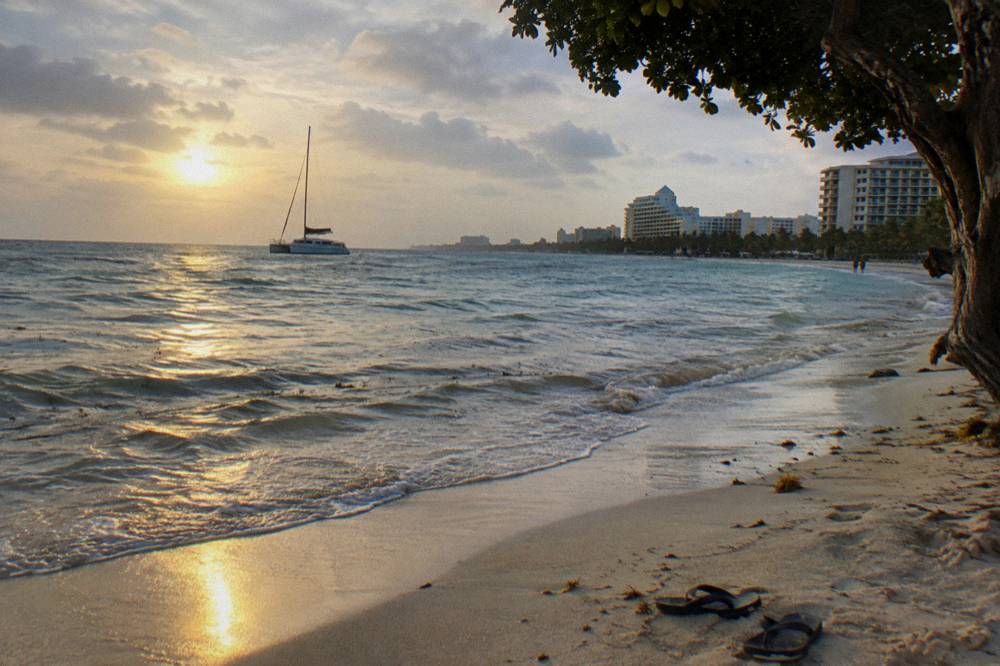 Glassy calm sea at sunset near the Palm Beach high-rise hotels with an anchored sailing boat