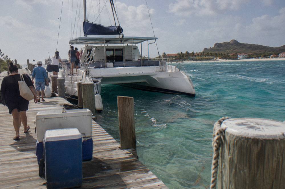 A luxury catamaran anchored near a Palm Beach pier in late afternoon light