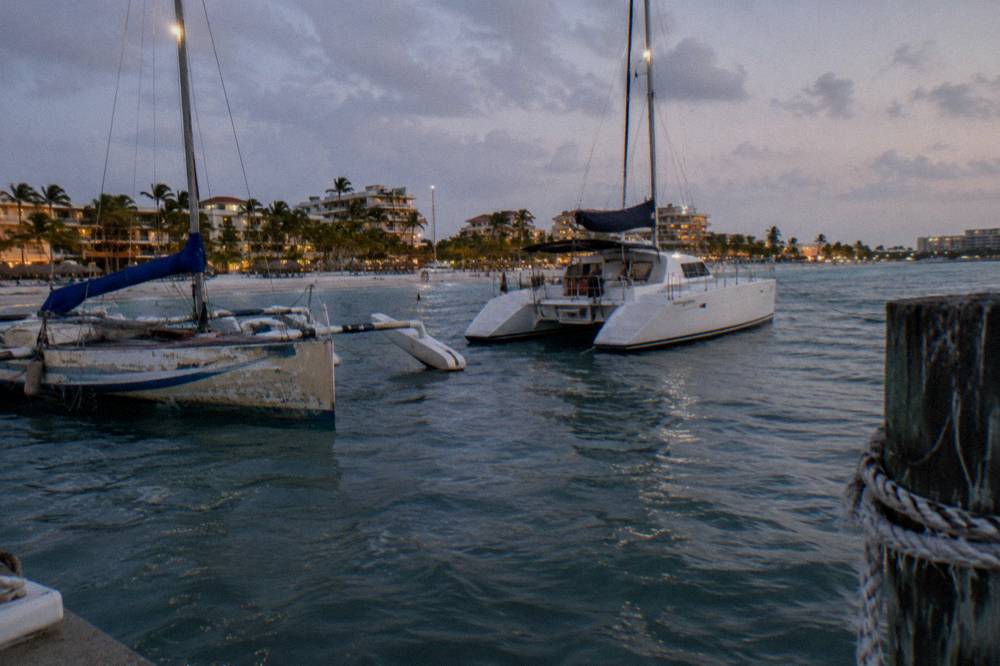 A trimaran and a catamaran moored near Palm Beach at dusk