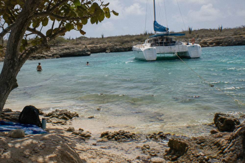 Shallow clear water over pale sand and patch coral inside a sheltered bay