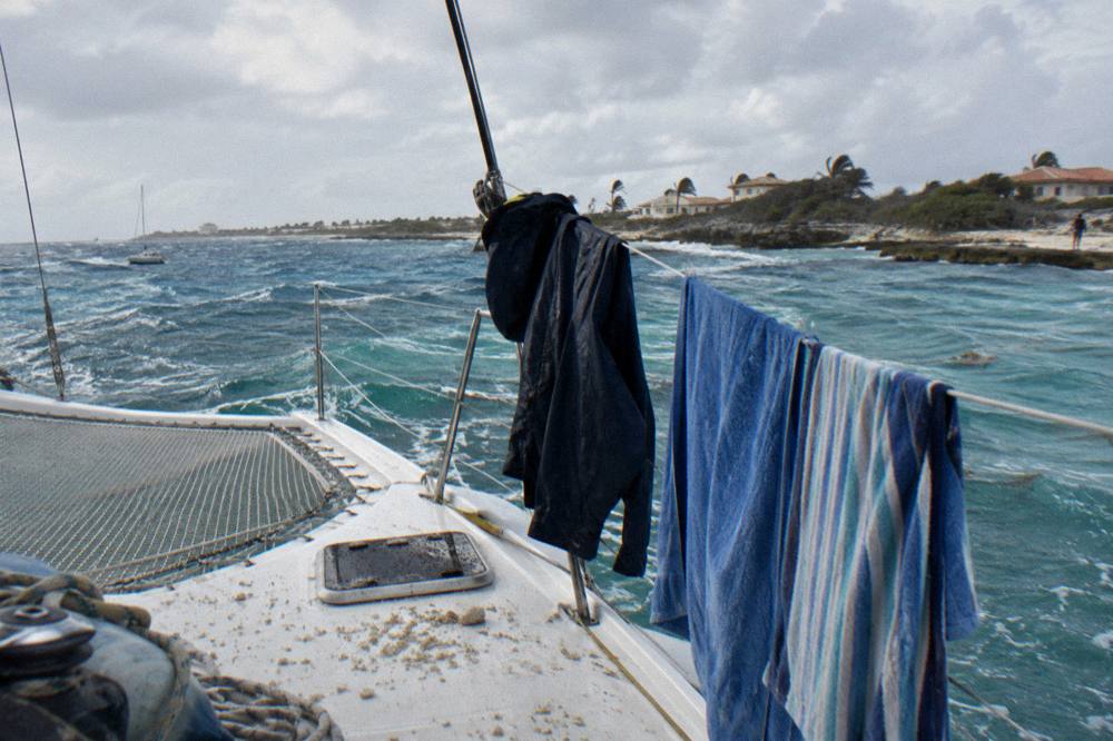 Boat deck with rain jacket and towels drying after a windy passage along the coast